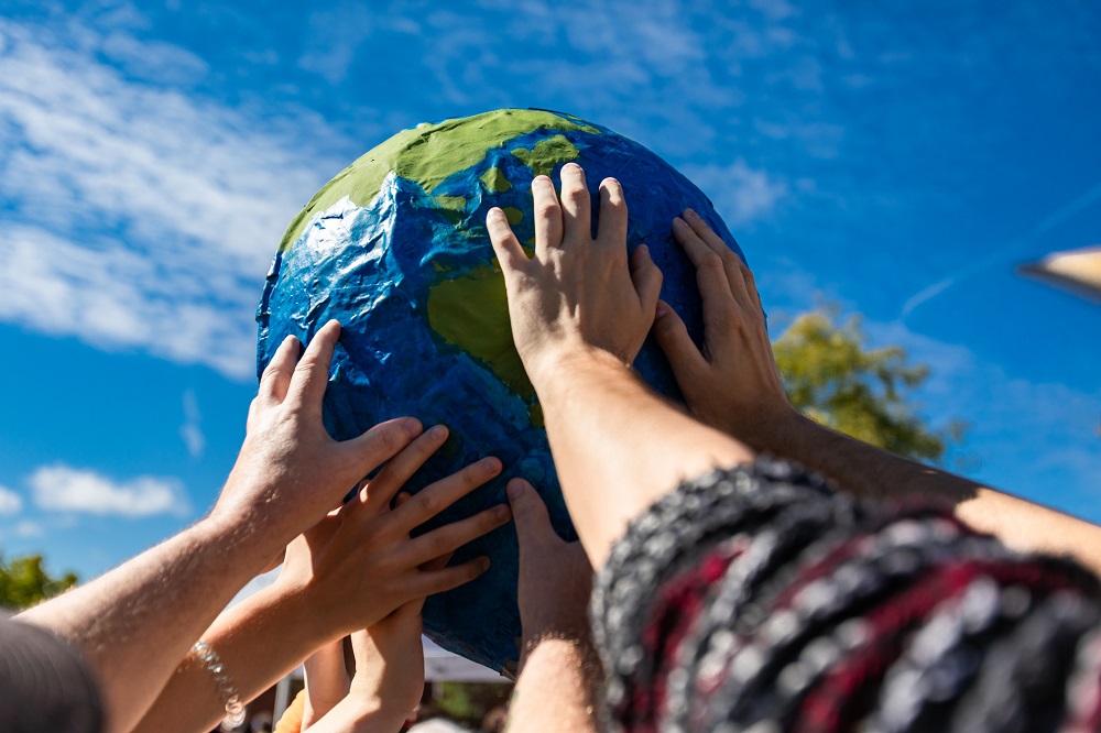 Close up of group of hands holding and protecting terra globe American continent. 